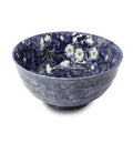 A Japanese porcelain bowl with a deep blue color and white floral patterns.