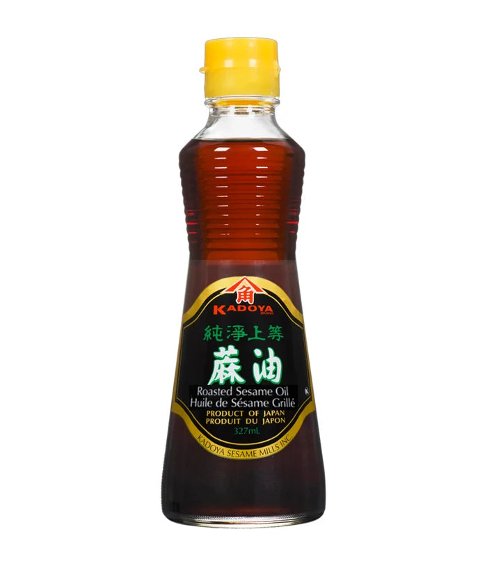 A bottle of Kadoya Roasted Sesame Oil 100% Pure with a yellow cap on a white background.